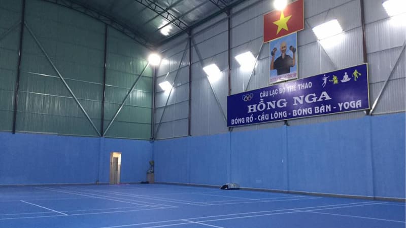 Hình ảnh sân cầu lông Hồng Nga với ánh sáng đèn LED trắng và khán đài nhỏ